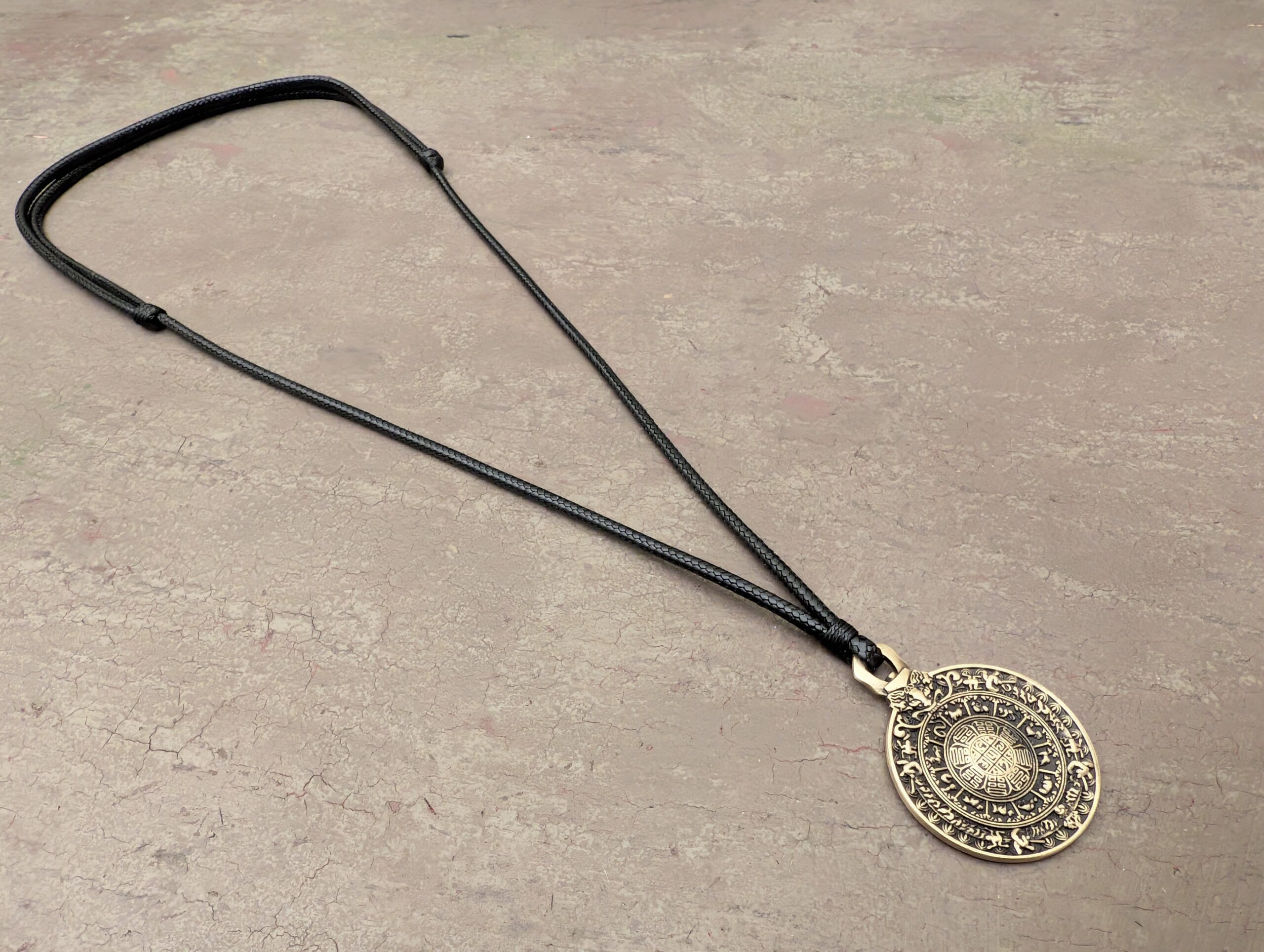 Bagua Spiegel Anhänger mit Ornament der acht Trigramme, Gesamtansicht mit Schnur auf neutralem Hintergrund